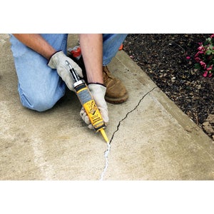 Crack sealant applied along a sidewalk crack with a caulking gun