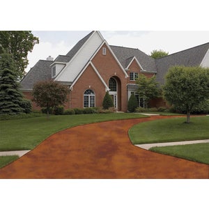 Coated concrete driveway in a red brown finish in front of a brick house