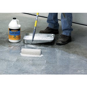 Concrete bonding adhesive rolled onto a slab with a paint roller and tray