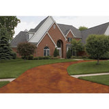 Coated concrete driveway in a red brown finish in front of a brick house