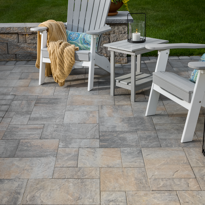 Finished grey paver patio with tight sand joints, Adirondack chairs and side table – polymeric sand patio result