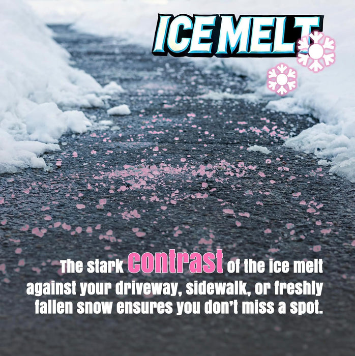 Pink ice melt granules scattered on dark asphalt driveway with snow banks on sides showing high-visibility contrast
