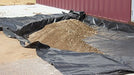 SRW SS5 woven geotextile installed over compacted subgrade before base aggregate is placed on a paver job